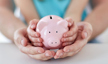 Young mother with child holding a pink biggy bank